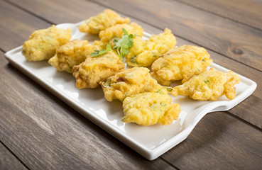 Cod fritters on brown wooden table. Spanish food.