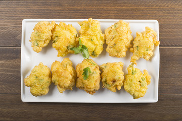 Cod fritters on brown wooden table. Spanish food.