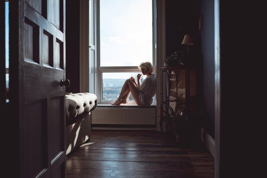 Woman sitting near window at home
