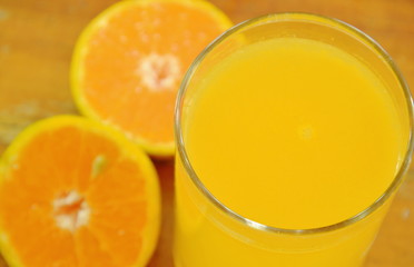 orange juice in glass and tangerine cutting on wooden board