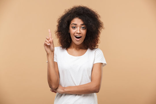 Portrait of an excited young african woman pointing finger