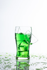 ​broken glass ice hand and green water on white background