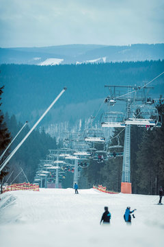 Ski lift on misty ski slope with skiers