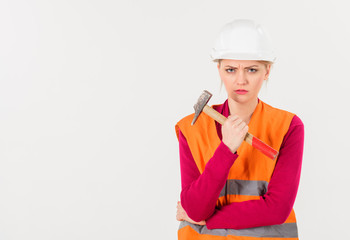 Girl in helmet or hard hat holds hammer, copy space.