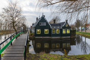 Beautiful and typical Dutch wooden houses architecture mirrored on the calm canal of Zaanse Schans located at the North of Amsterdam, Netherlands