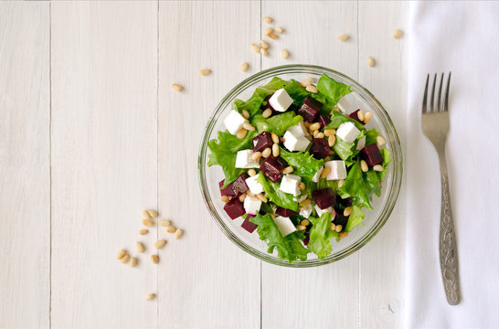 Salad of Beetroot, Feta cheese and lettuce leaves with pine nuts. Empty space