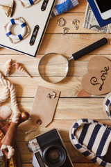 Striped slippers, camera, phone and maritime decorations on the wooden background