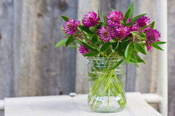 bouquet of red clover in a glass jar.