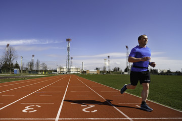 Fototapeta premium Male sprinter in middle age trains for race competition