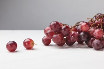 Close up view of pile of red grapes on gray