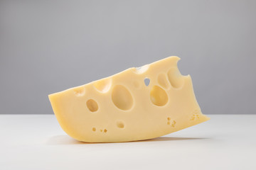 Close up image of maasdam cheese on gray