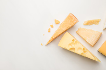 Top view of various types of cheese on white