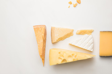 Top view of different types of cheese on white
