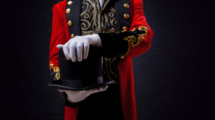 Magician. Close-up of hand in gloves The guy in the red camisole and the cylinder.