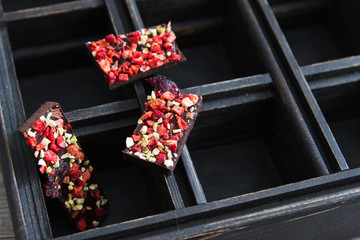 Selective focus dark milk chocolate berry square box background.