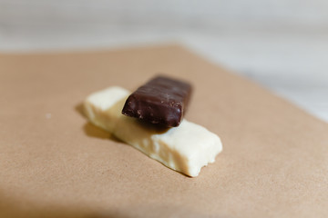 Closeup protein bars on the baking paper, Teflon paper, Diet snacks, sports nutrition. Whey protein powder and chocolate protein bar on wooden background. Snack before workout bodybuilding