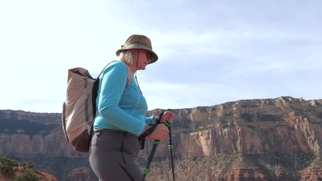 Fat Mature Woman With Trekking Poles And A Backpack Hiking In The Grand Canyon