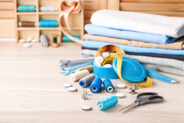 Accessories to sewing - fabric, a thread and a button. Selective focus. Copy space