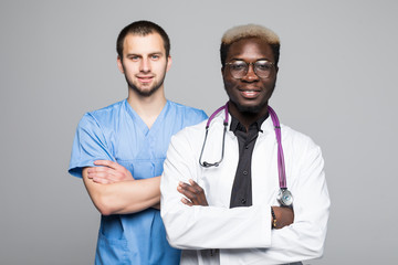 Portrait of doctor and surgeon men standing with arms folded isolated on gray background