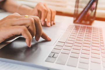 Close up woman working at home office hand on laptop.