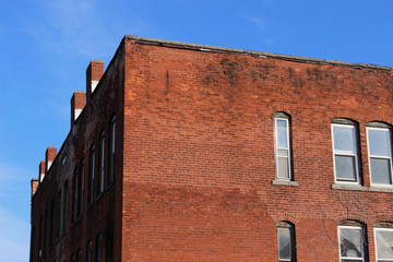 Boarded up windows on abandoned industrial urban brick factory building 