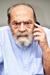 Fototapeta premium Hispanic Male Using Cell Phone And Unhappy