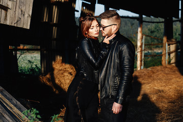 Obraz na płótnie Canvas fashion guy with his girlfriend stand in black leather jackets and look at each other