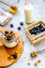 Morning granola with yogurt, honey and berries on white table