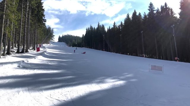 People ski down a snowy hill