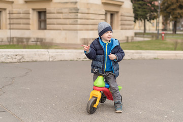 Young boy in the park with his running bike