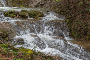 Wasser fliesst im Bach über Wasserfall