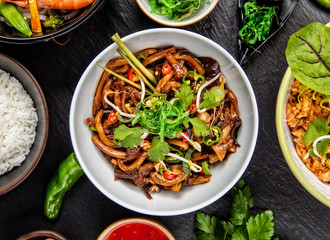 Asian udon noodles with spicy soy sauce and chicken pieces, top view