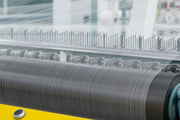 macro shooting of cotton thread twisting on the shaft. machinery and equipment in a textile factory