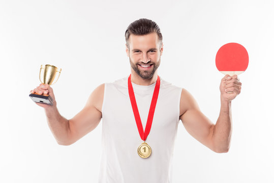 First runner up, attractive, powerful, sporty, athletic, strong table tennis winner having gold medal with red ribbon on his neck, having, showing trophy and racket, isolated on white background