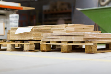 production, manufacture and woodworking industry concept - wooden boards and chipboards storing at furniture factory