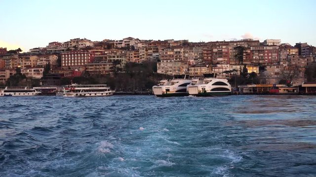 The ferry left the pier, the old district of Istanbul behind the stern of the ship. A ferry is public transport to transport people to the other side of the Bosphorus.