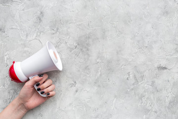Announcement concept. Megaphone in hand on grey background top view copy space