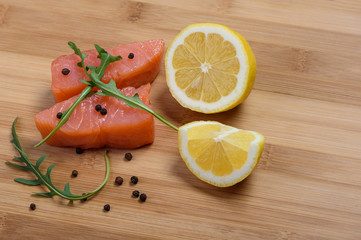 Pieces of salmon with arugula, pepper and lemon