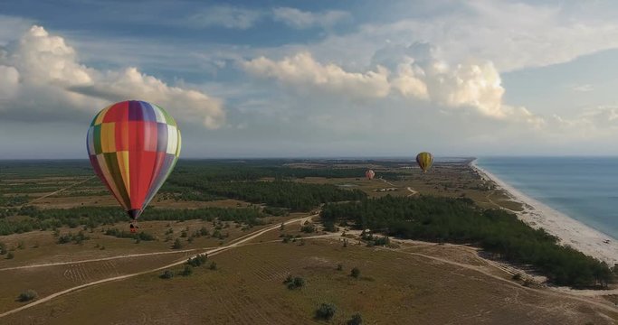 Aerial view, Hot air balloon in sky over field and forest in summer landscape shores sea
