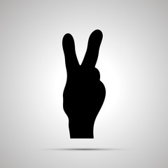 Black silhouette of hand in victory gesture on white