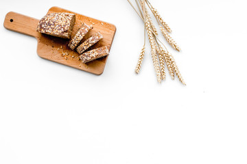 Homemade fresh bread sliced on cutting board on white background top view copy space