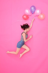 A beautiful woman is flying on balloons towards her dream.