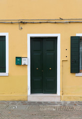 Green door on yellow facade
