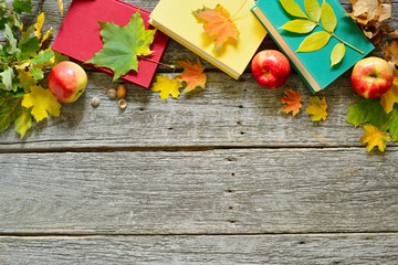 Vintage Autumn table with apples, fallen leaves, vintage books, cup of coffee or tea on old wooden table