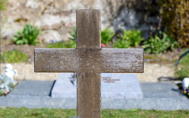 Simple wooden cross on a grave in a cemetery