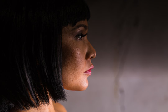 Young Pacific Islander Woman With Serious Expression In A Grungy Location