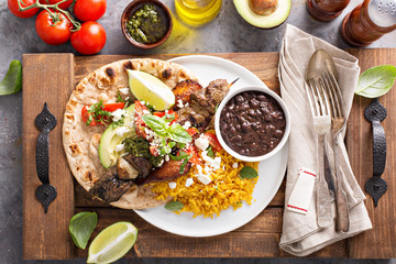 Beef kebab with rice, beans and fried plantains