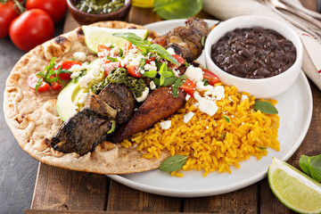 Beef kebab with rice, beans and fried plantains
