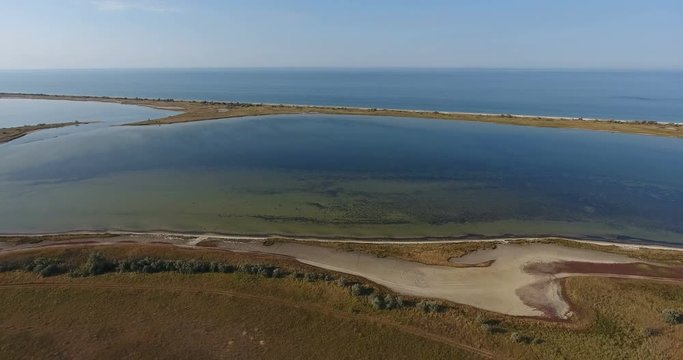 Aerial fantastic view flight of drones over the water of a salt lake on the shore of an island in middle of sea, kinburn foreland