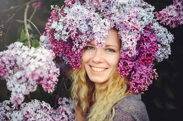 Outdoor fashion photo of a beautiful young blue-eyed woman. Spring color. beautiful blonde girl in lilac flowers. Perfume with a scent of flowers. Perfumes and beauty